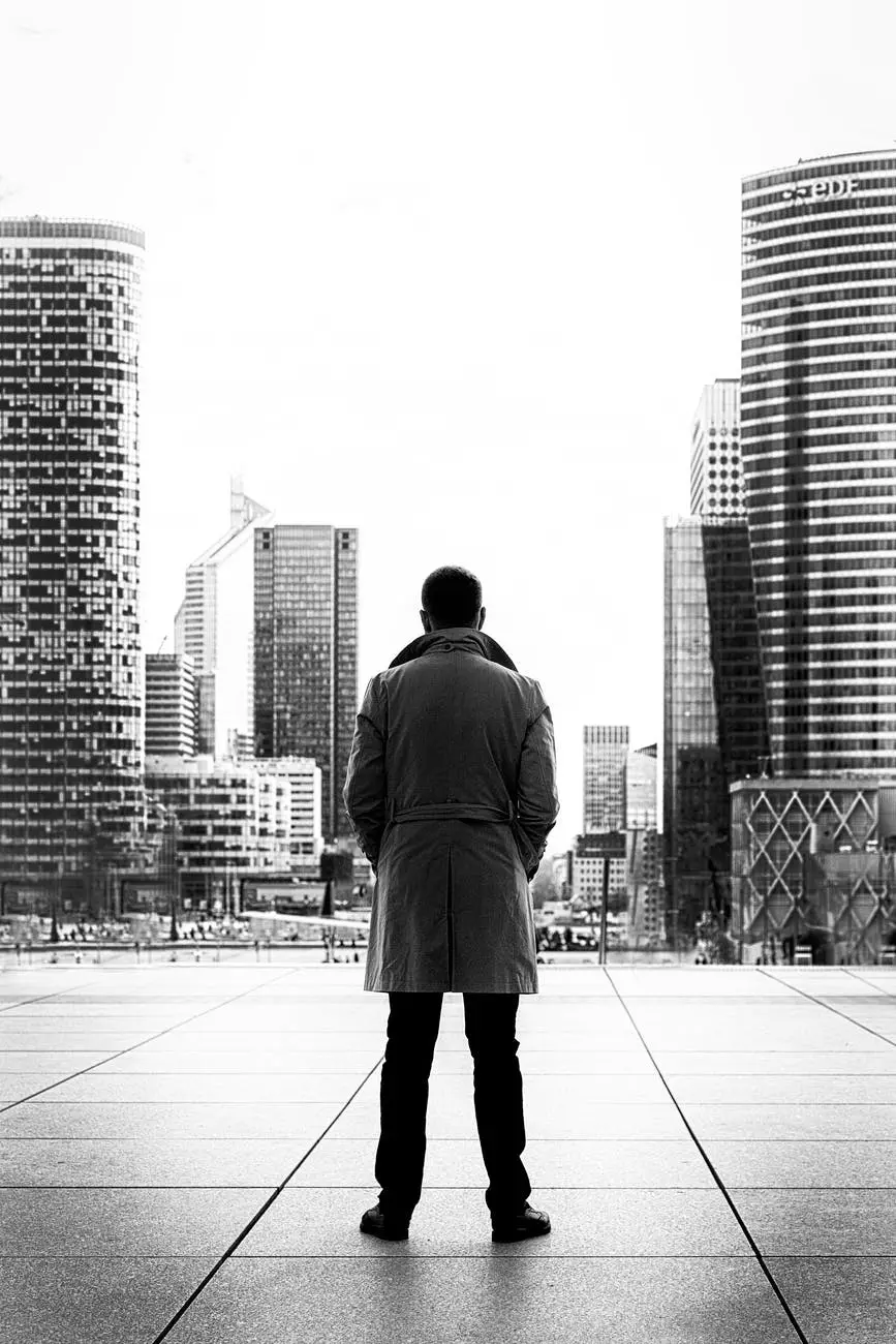 man standing looking at a city black and white