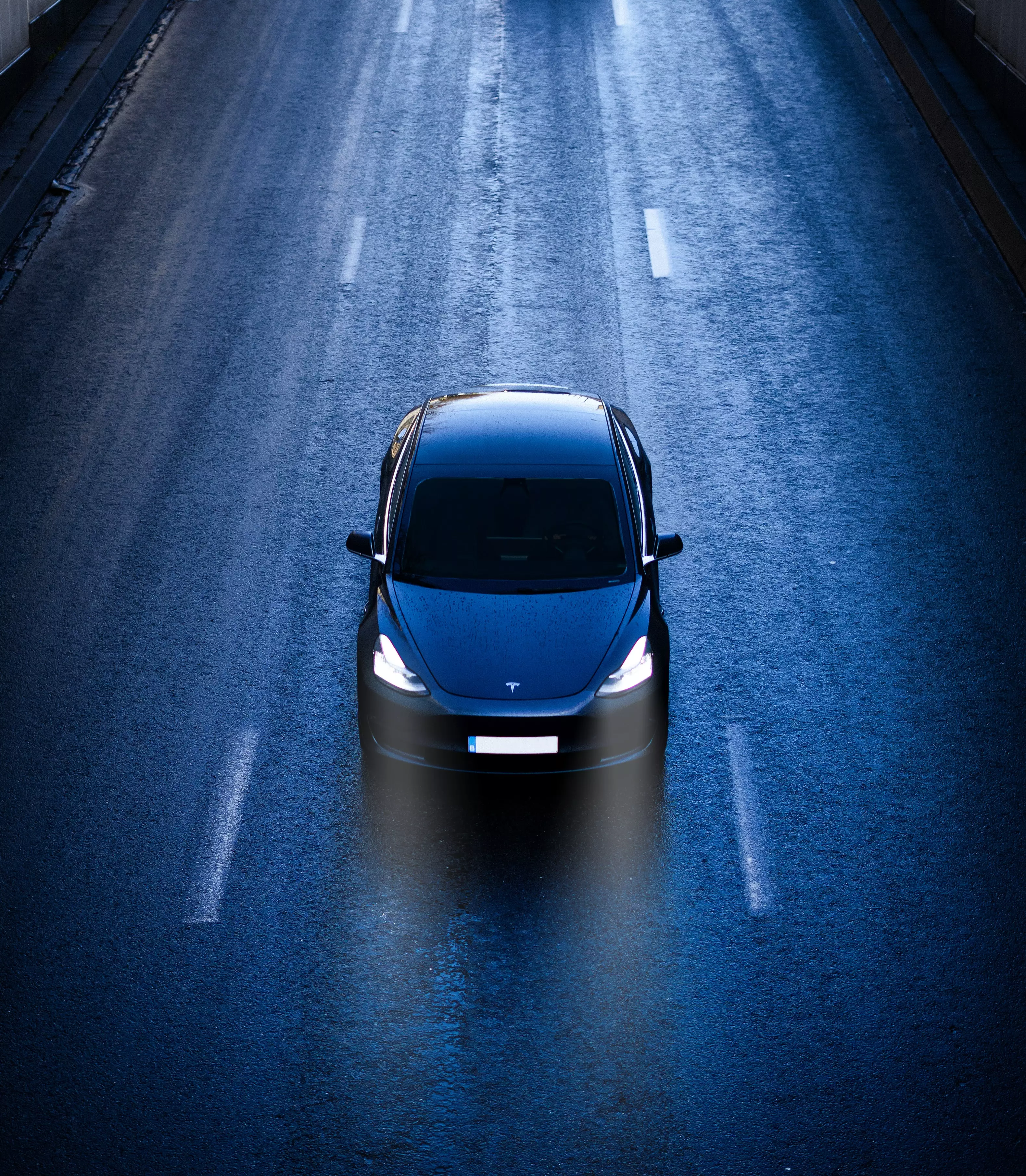 Tesla Model 3 driving down dark road